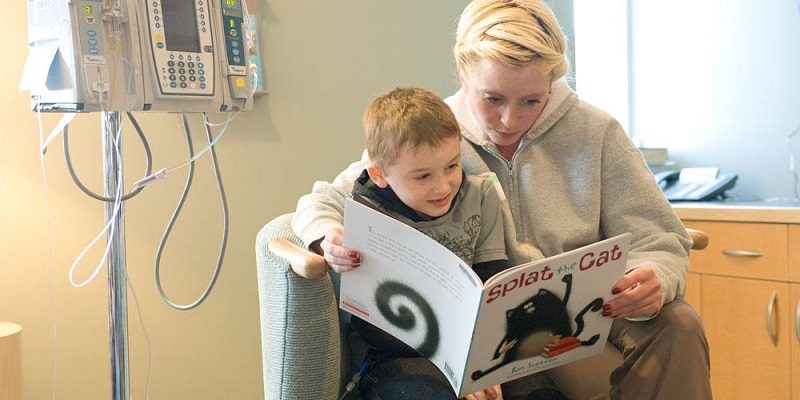 A mother reads with her child as he receives an infusion of stem cells for autism.